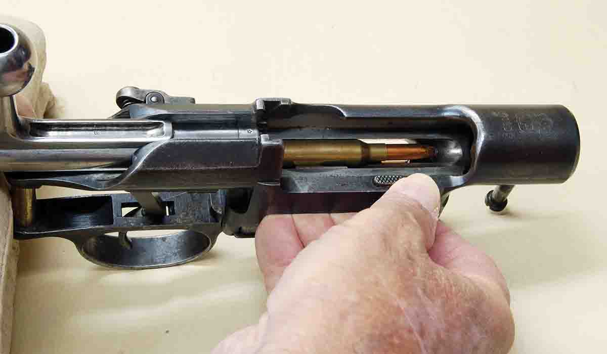 The thumb is on the release button of the M-S action, which allows all rounds in the magazine to be ejected into a waiting hand.